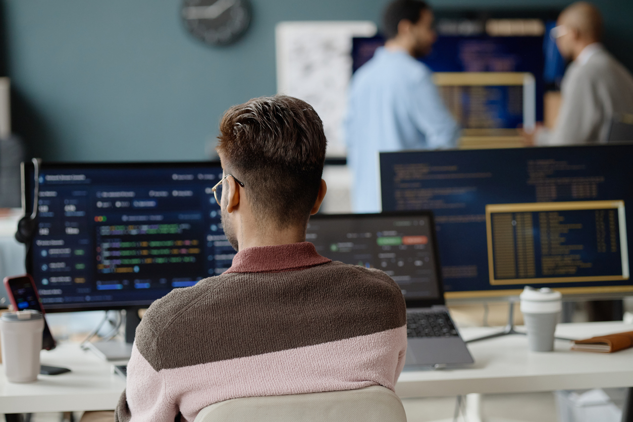 Çok monitörlü operasyon masasında bir mühendis